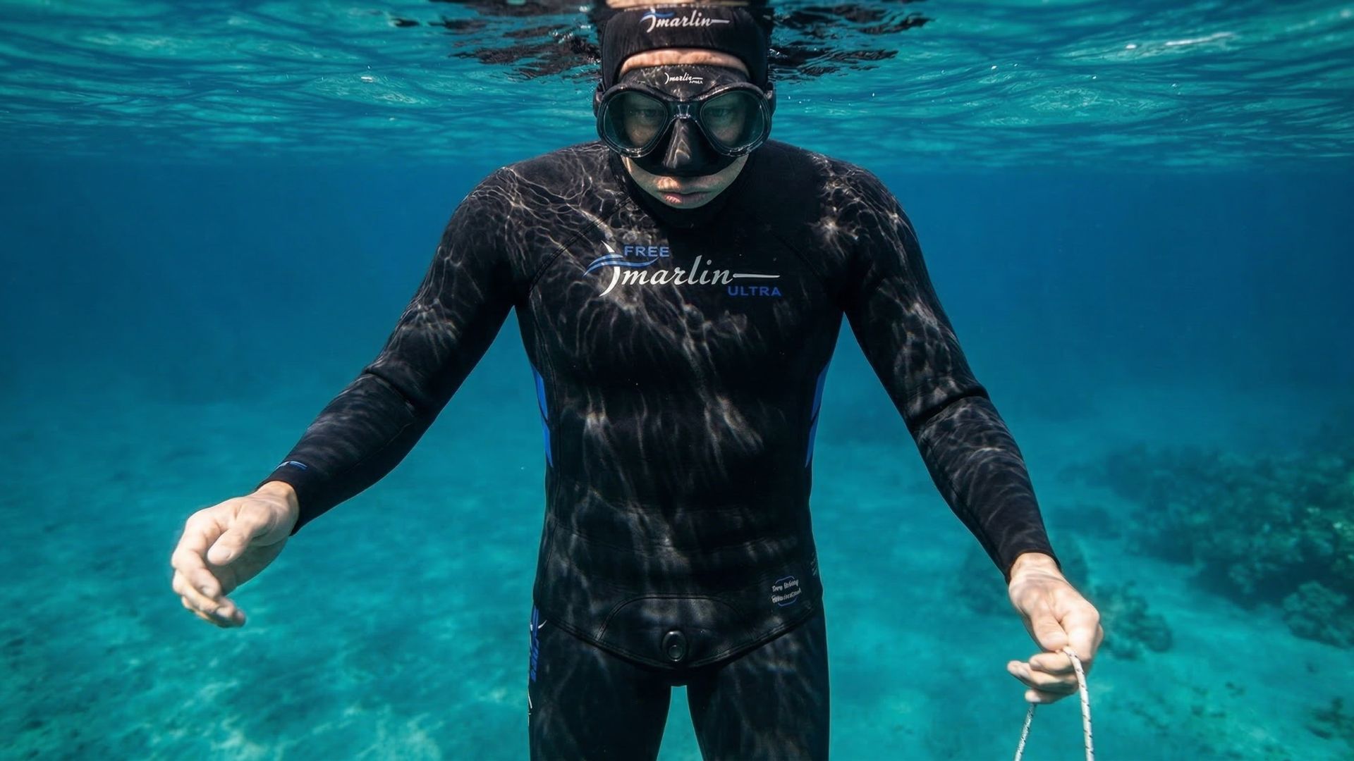 Apneísta estático bajo el agua encarándose hacia la cámara